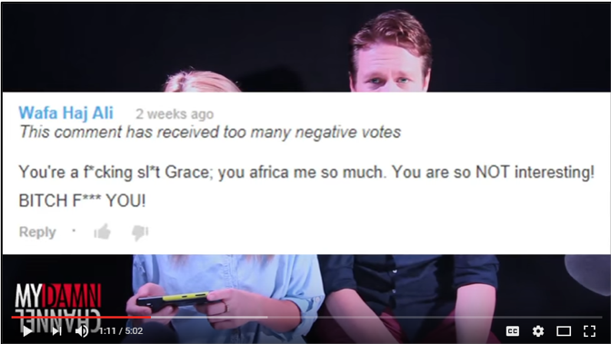 Grace Helbig and Pete Holmes are almost completely obscured by screencap of a YouTube comment that says “You’re a f*cking sl*t Grace; you africa me so much. You are so NOT interesting! BITCH F*** You!”