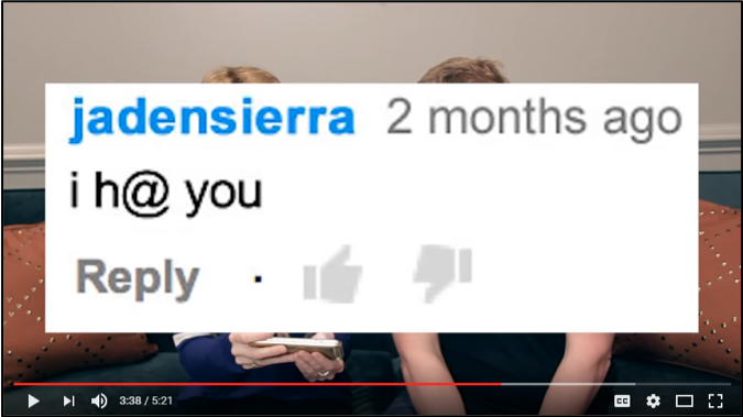 Grace Helbig and James Corden are almost completely obscured by a screencap of a YouTube comment that says “i h@ you.”