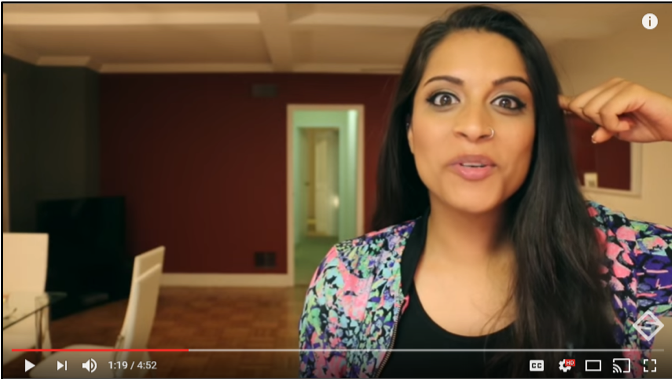 Lilly Singh points to her head and makes a sarcastic face while she says “My brain is controlled by the media and I blindly accept information. Now I’d love to stay and chat, but I have to forward this scary email to 70 people in the next seven minutes or a ghost is going to kill me.”