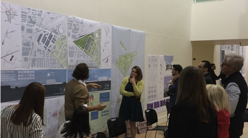 Image of students and teachers looking at maps and drawing on the wall.
