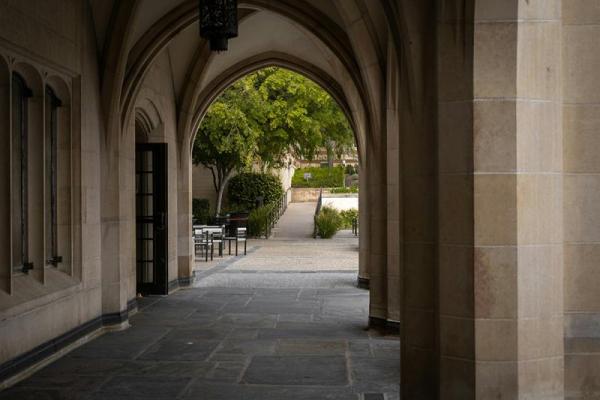 Corridor in front of college building under arches.