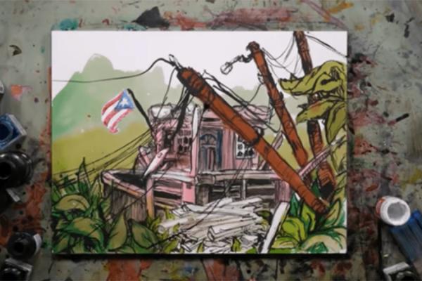 A painting on a work surface depicting a damaged house with fallen power line poles, a Puerto Rican flag, and overgrown vegetation, surrounded by ink and paint bottles.
