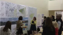 Image of students and teachers looking at maps and drawing on the wall.