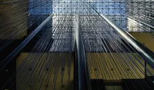 Upward view of thin metal rods or cables radiating outward from vertical columns inside a large atrium with a geometric glass ceiling.