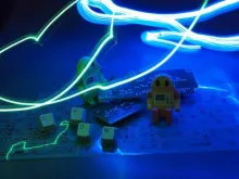 small toy robots with light painted over them