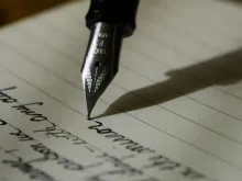 A fountain pen writes on paper.