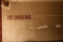 "No Smoking" written on a distressed wall.
